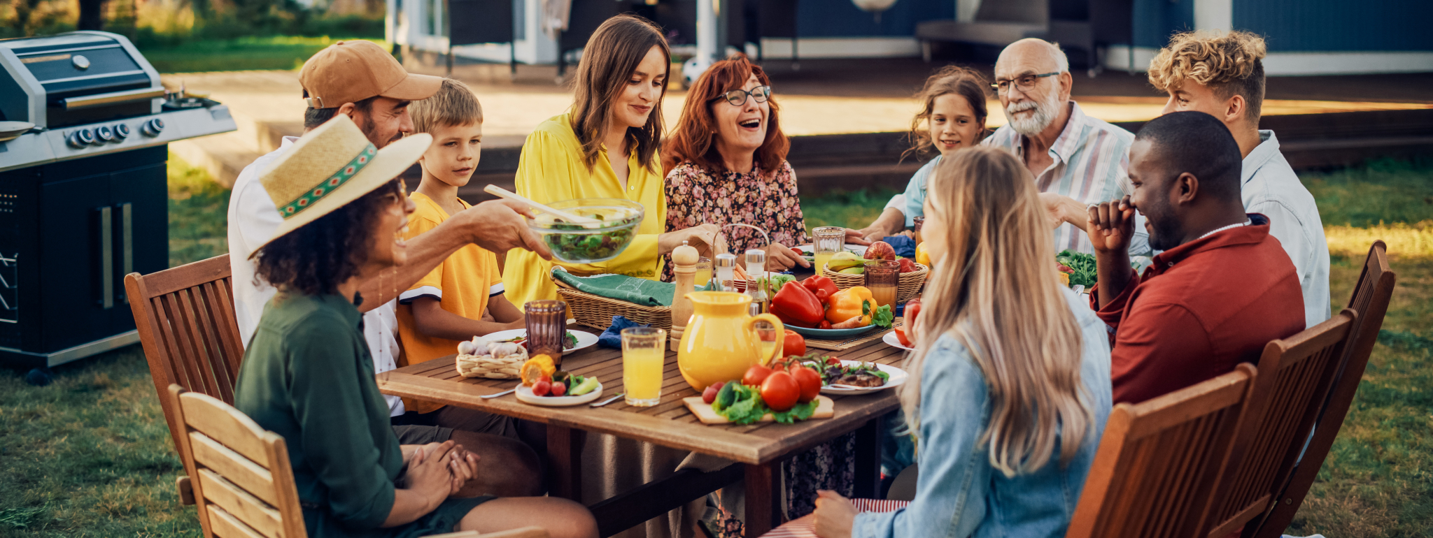 A group of people at a picnic table eating and laughing